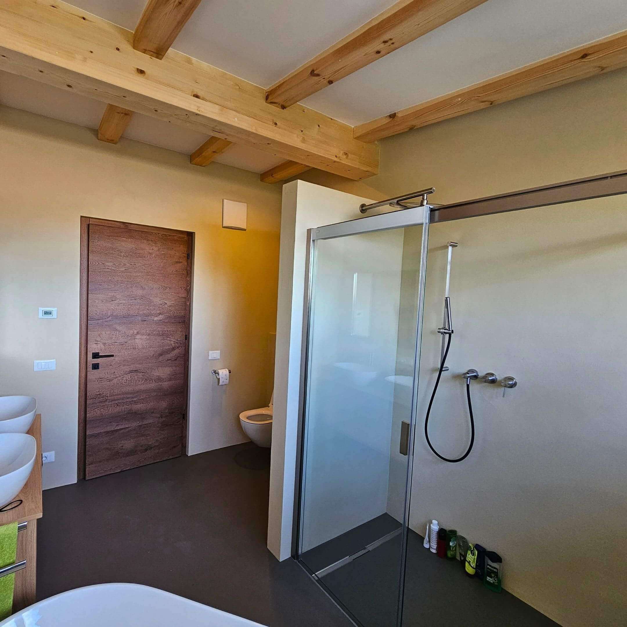 Badezimmer mit fugenloser Wandbeschichtung und Holzdecke