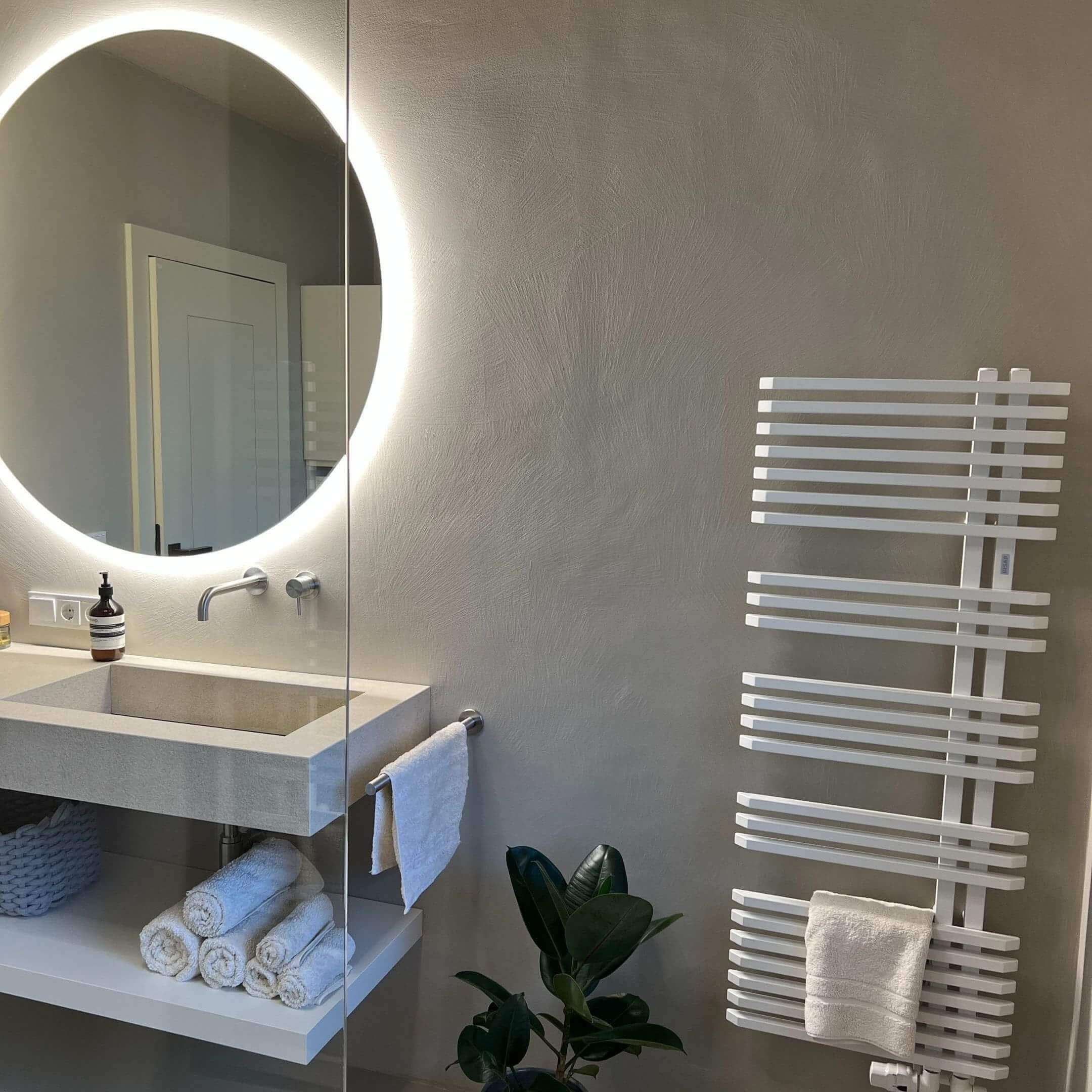 Moderner Waschplatz mit fugenloser Oberfläche und integrierter Beleuchtung