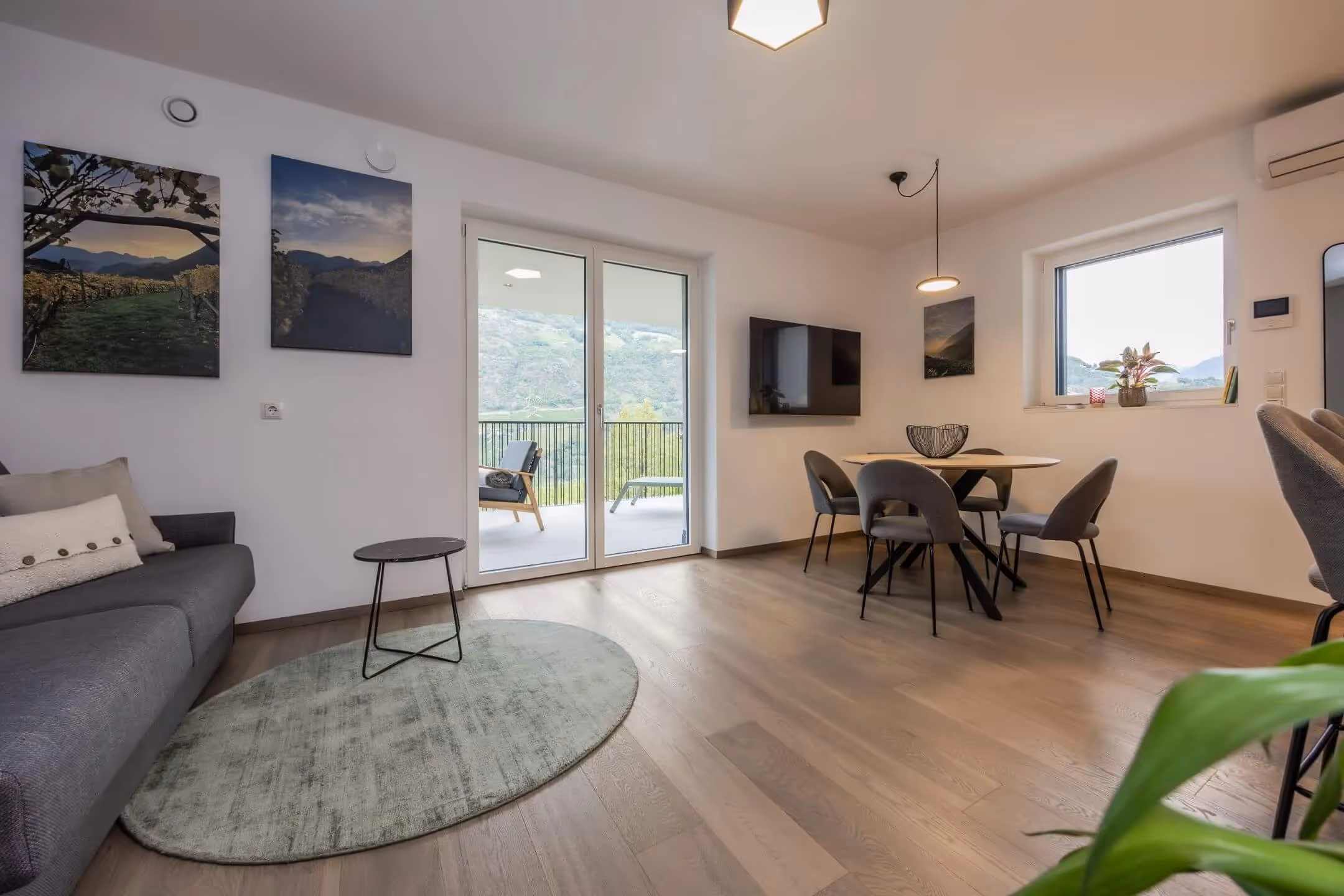 Wohnzimmer mit Holzboden und großen Fensterflächen