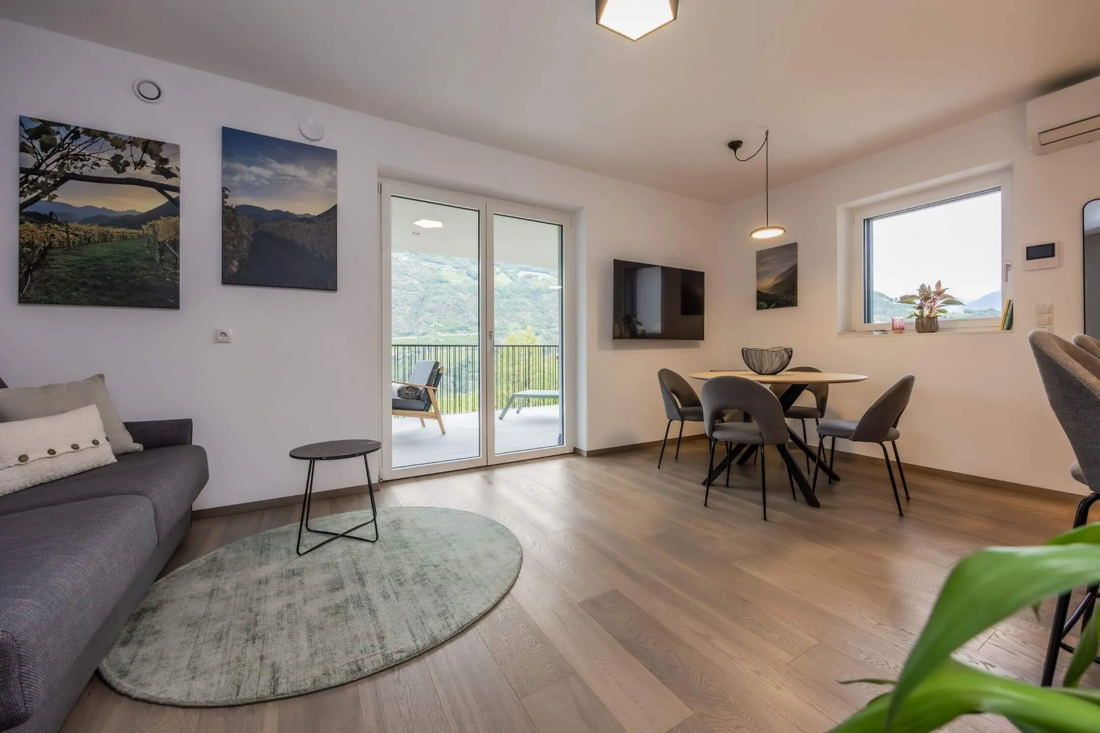 Wohnzimmer mit Holzboden und großen Fensterflächen