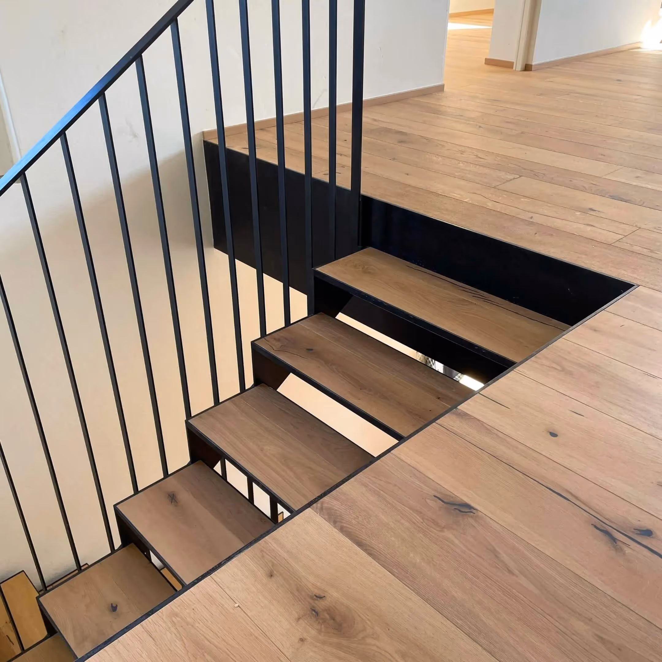 Galeriegeschoss mit Holzboden und schwarzem Metallgeländer