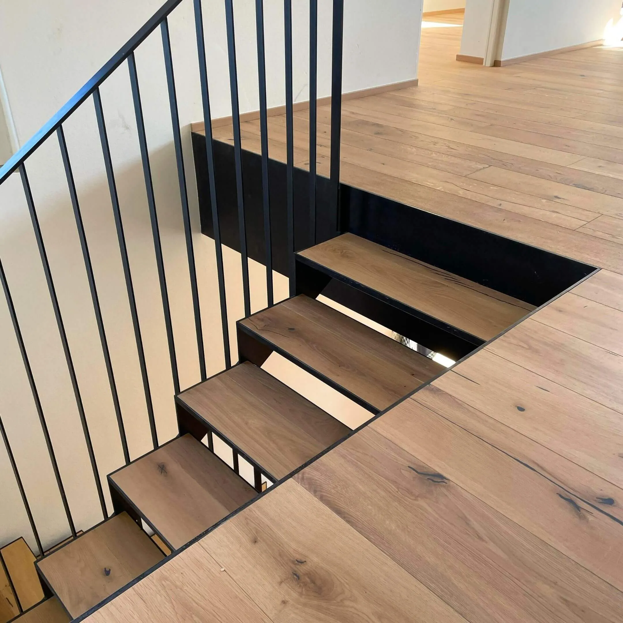 Galeriegeschoss mit Holzboden und schwarzem Metallgeländer