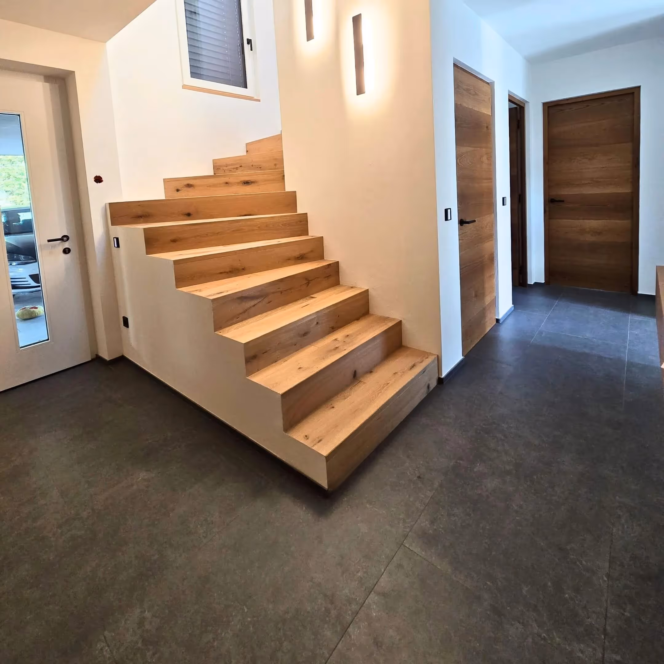 Treppenaufgang mit massivem Holzstufenbelag und klarer Linienführung