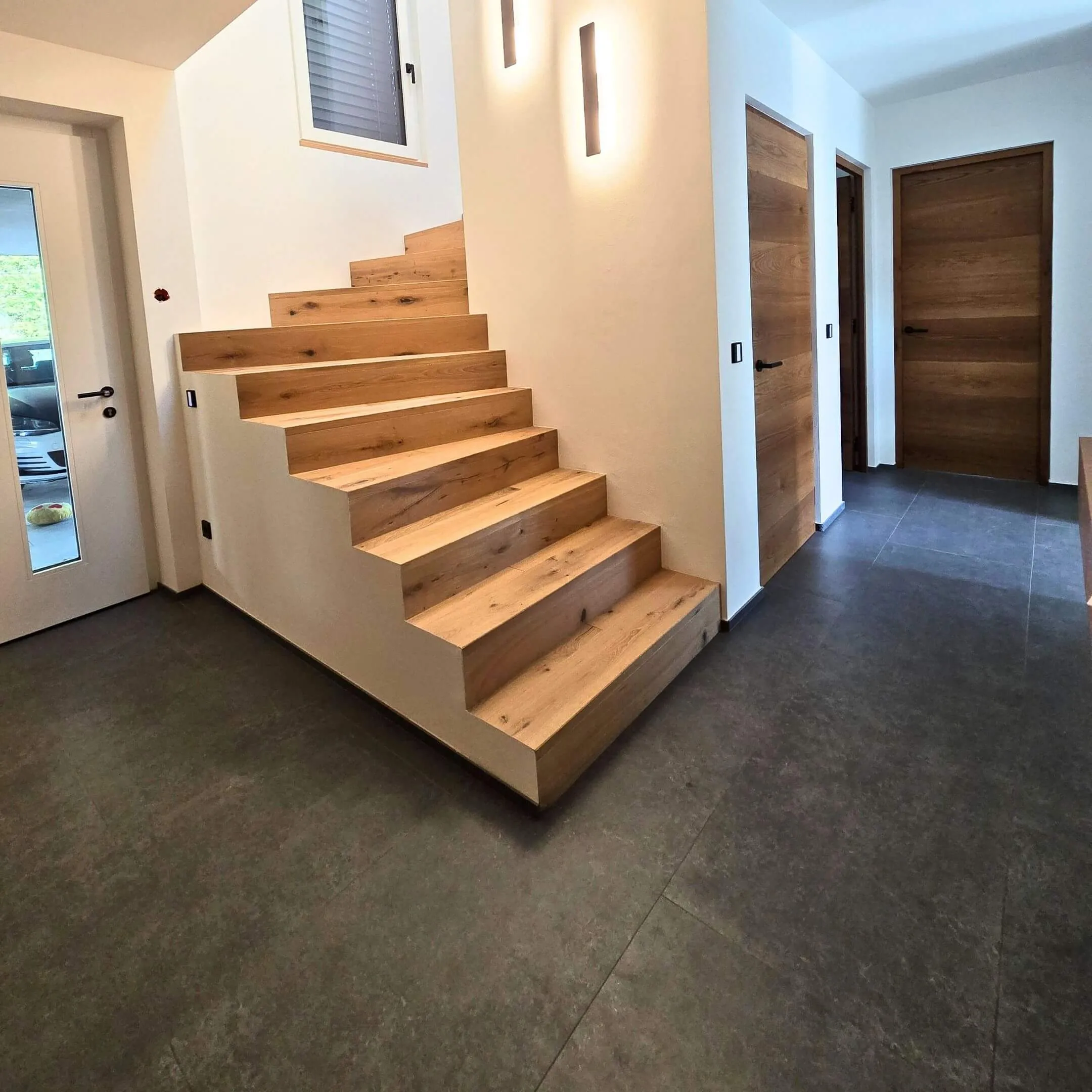 Treppenaufgang mit massivem Holzstufenbelag und klarer Linienführung