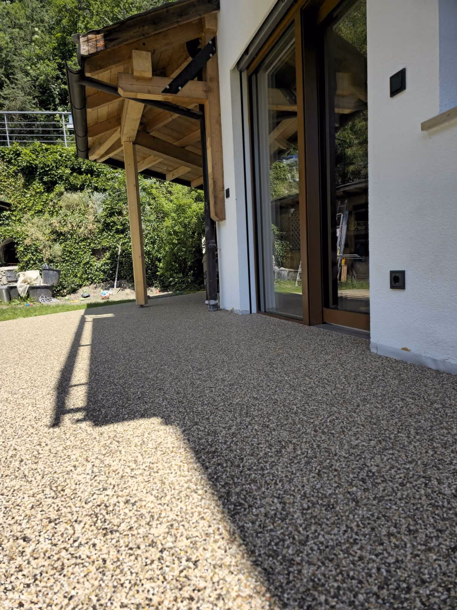 Steinteppich auf Terrasse entlang der Hausfassade