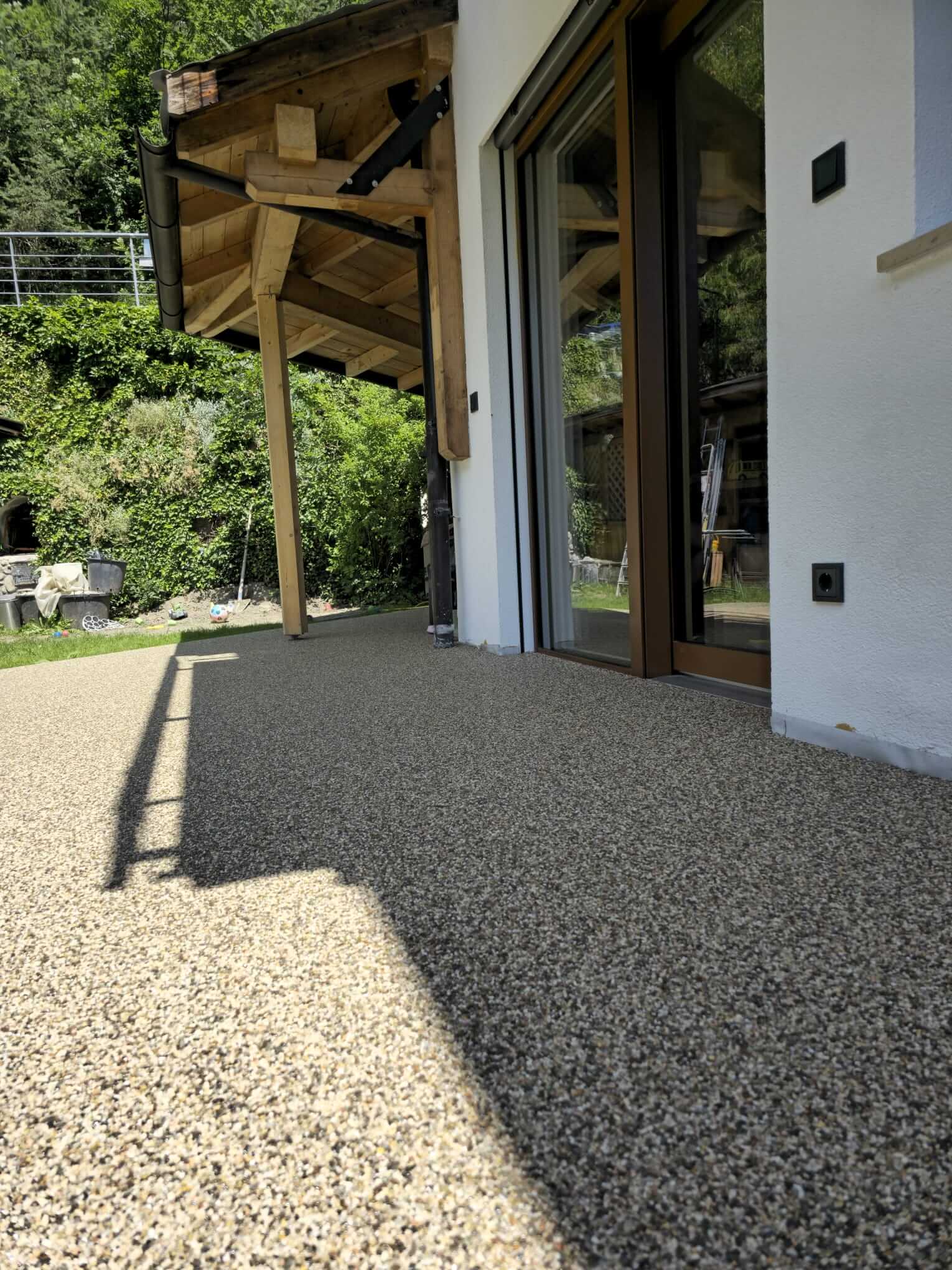 Steinteppich auf Terrasse entlang der Hausfassade