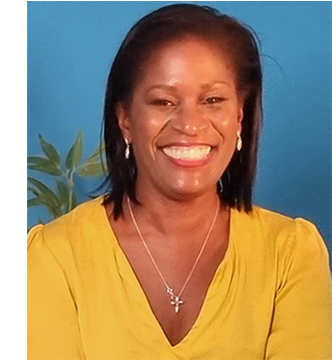 Smiling woman with short dark hair wearing a yellow top and a silver cross necklace against a blue background.