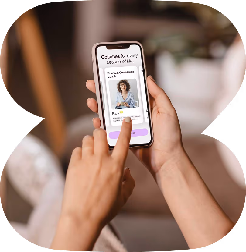 Person holding a smartphone showing a coaching app with a profile of Priya, a Financial Confidence Coach.