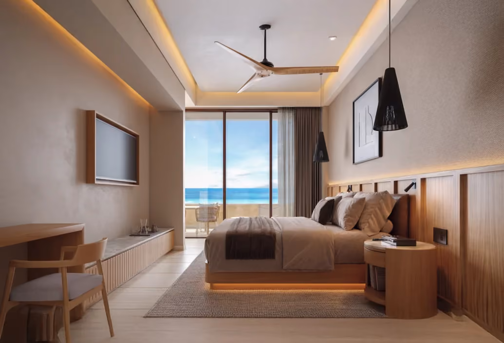 Modern bedroom with a king-sized bed featuring brown and beige bedding, wooden headboard and round bedside table, pendant lights, ceiling fan, and a large sliding glass door opening to a balcony with ocean view.