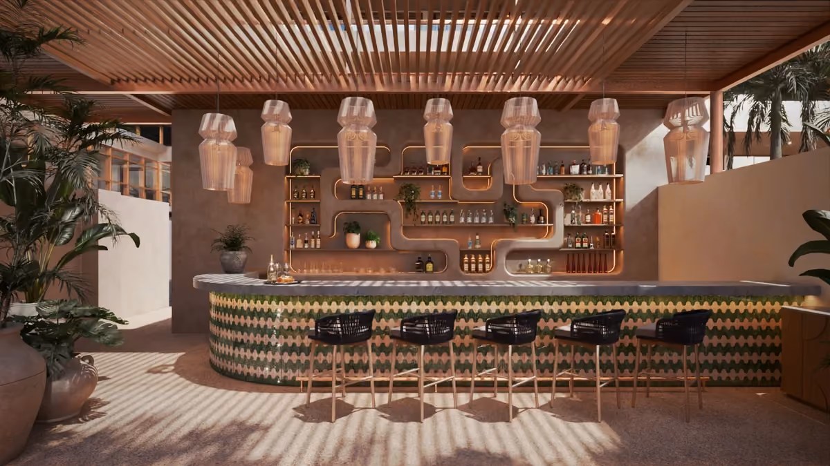 Modern outdoor bar with a curved counter decorated in green and white patterns, five black wicker bar stools, hanging pendant lamps above, and back shelves with bottles and plants against a beige wall under a wooden slatted roof.