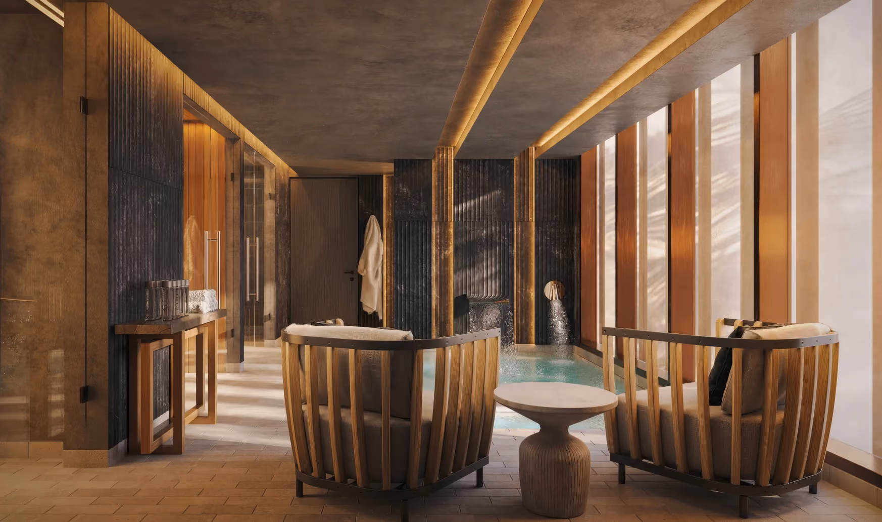 Modern spa room with two wooden-framed cushioned armchairs facing a small indoor pool with water flowing from wall spouts, warm lighting, and vertical wooden panels on windows.