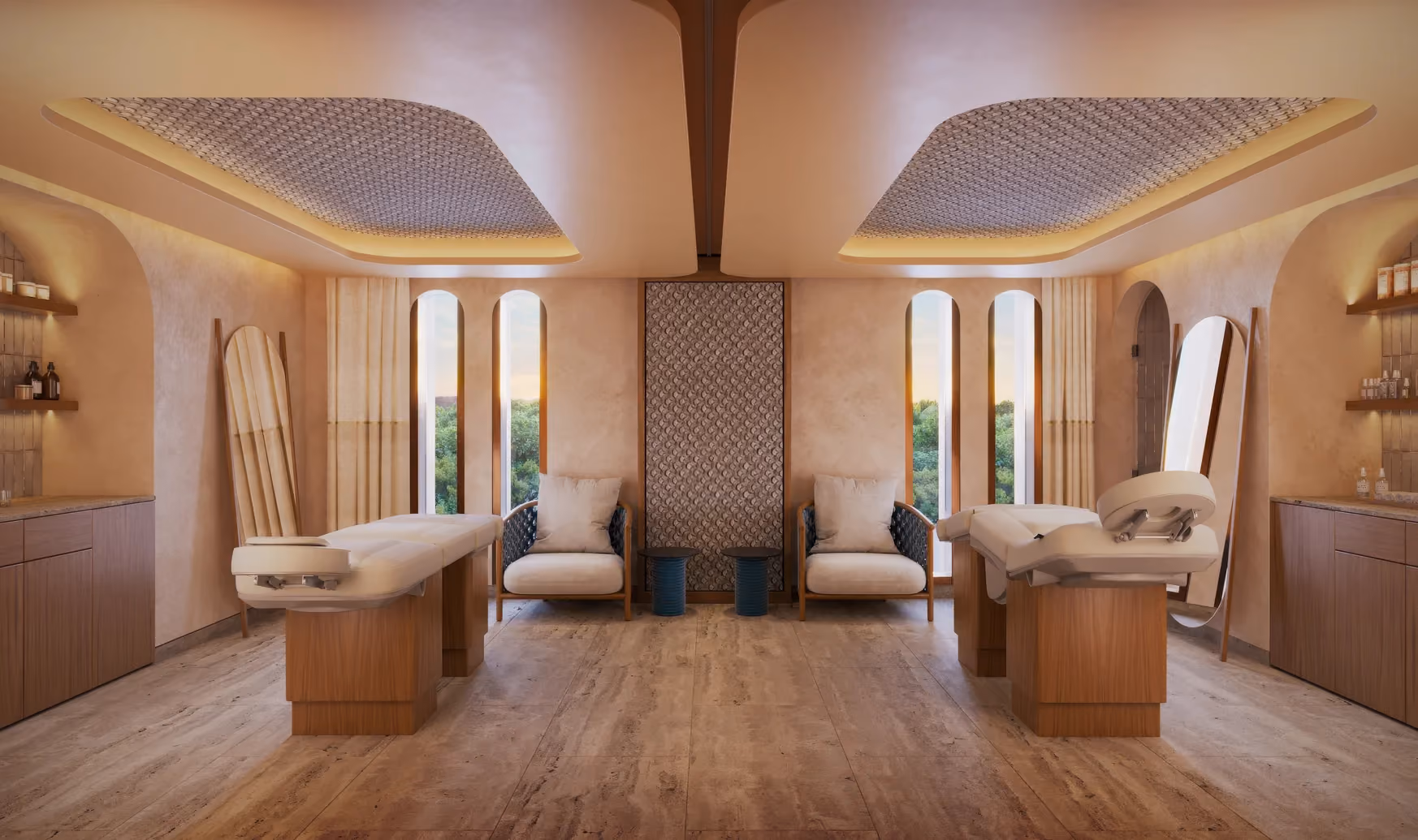 Symmetrical spa treatment room with two padded massage tables on wooden bases, two cushioned armchairs with pillows, small side tables, tall mirrors leaning against the wall, and shelves holding spa products, all illuminated by soft, warm lighting and framed by narrow, arched windows showing greenery outside.