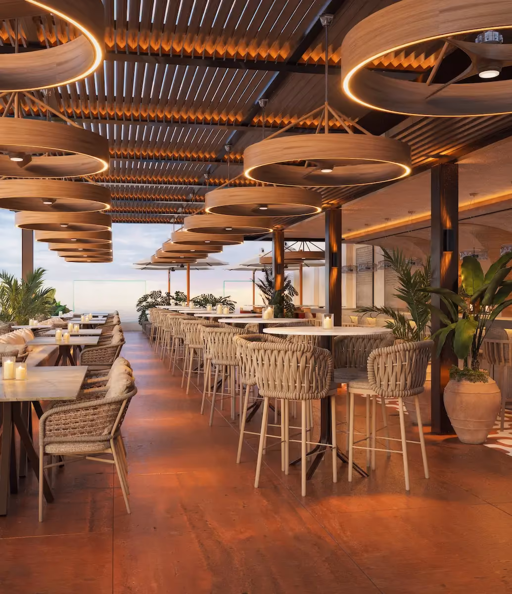 Modern rooftop restaurant with wooden circular pendant lights with warm glow, woven chairs around marble tables, potted green plants, and a wooden slatted pergola ceiling.