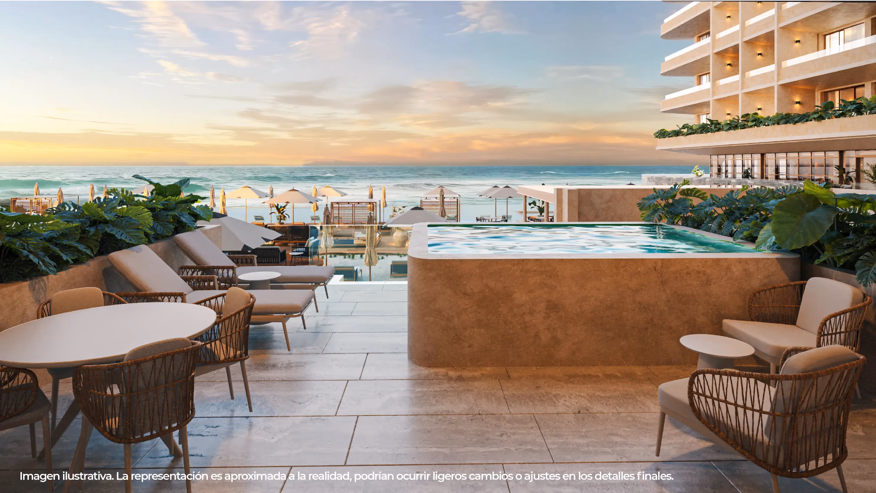 Modern beachfront hotel terrace with a large rectangular hot tub surrounded by green plants, beige lounge chairs, and wicker patio furniture overlooking the ocean at sunset with beach umbrellas visible along the shore.