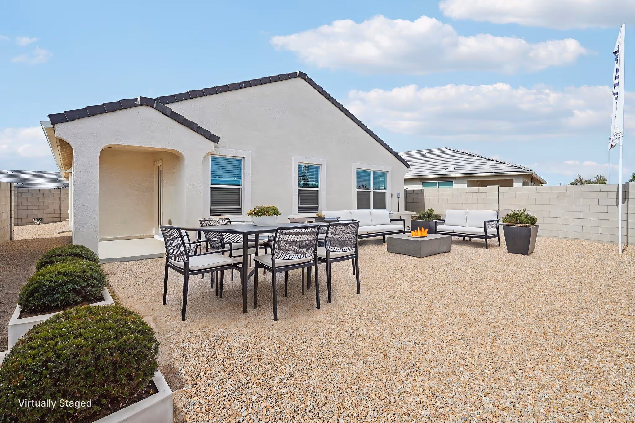 Staged backyard exterior with seating and outdoor fireplace