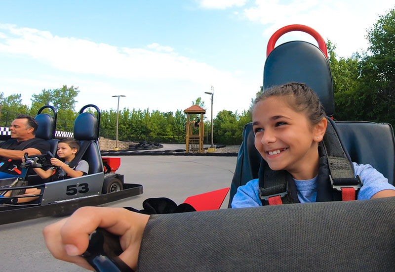 Girl driving a gokart with her family