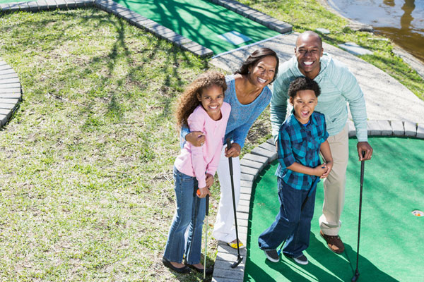 Family playing putt putt golf