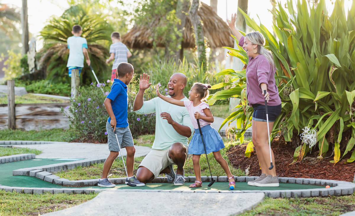 Happy family playing miniature golf