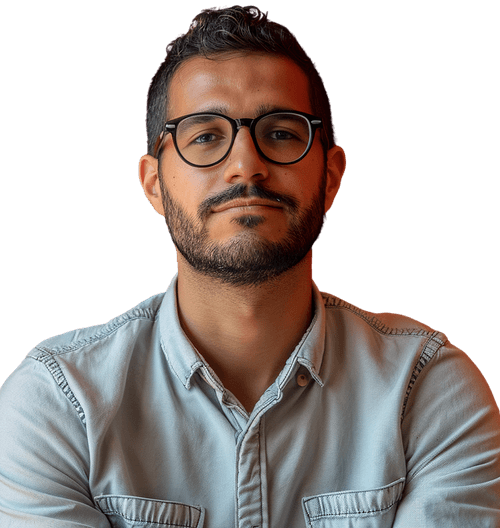 Man with dark hair and beard wearing glasses and a light denim shirt looking confidently at the camera.