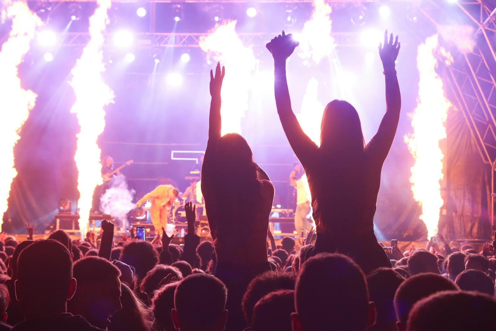 Crowd at an outdoor summer evening concert facing a stage