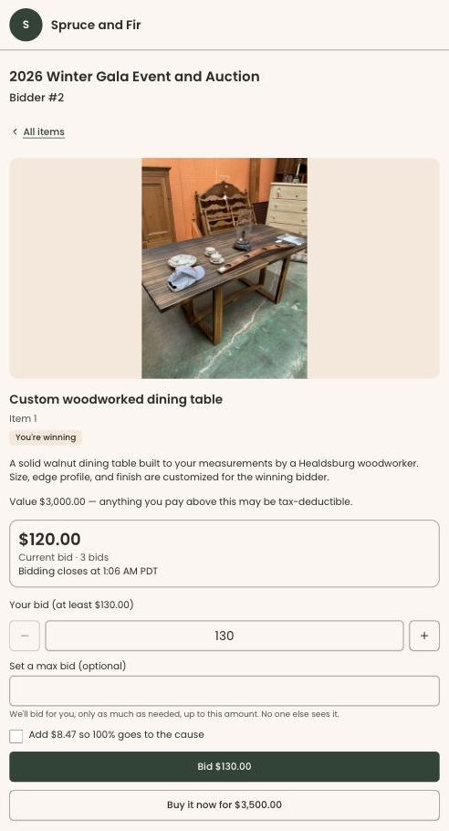 A guest's phone showing a custom dining table with its photo, description, value, current bid, a bid amount, an optional max bid, a box to cover the processing fee, a Bid button and a Buy it now button