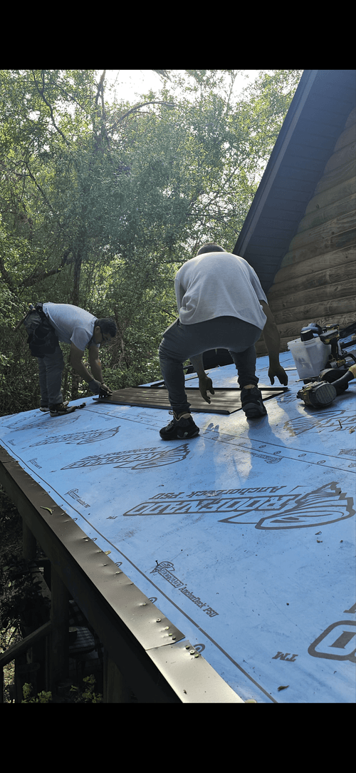 a couple of men working on a roof