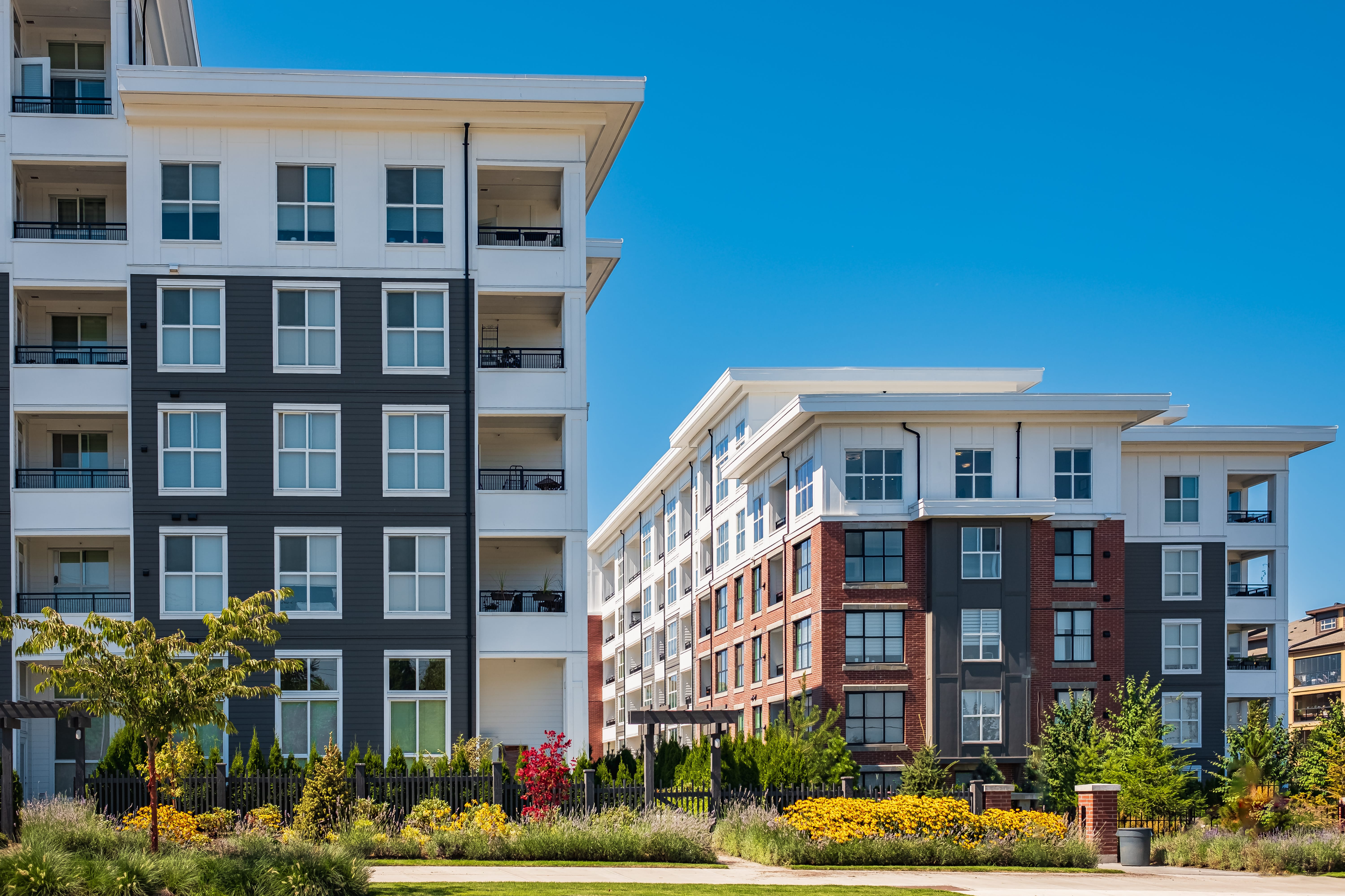 a group of buildings with trees and flowers