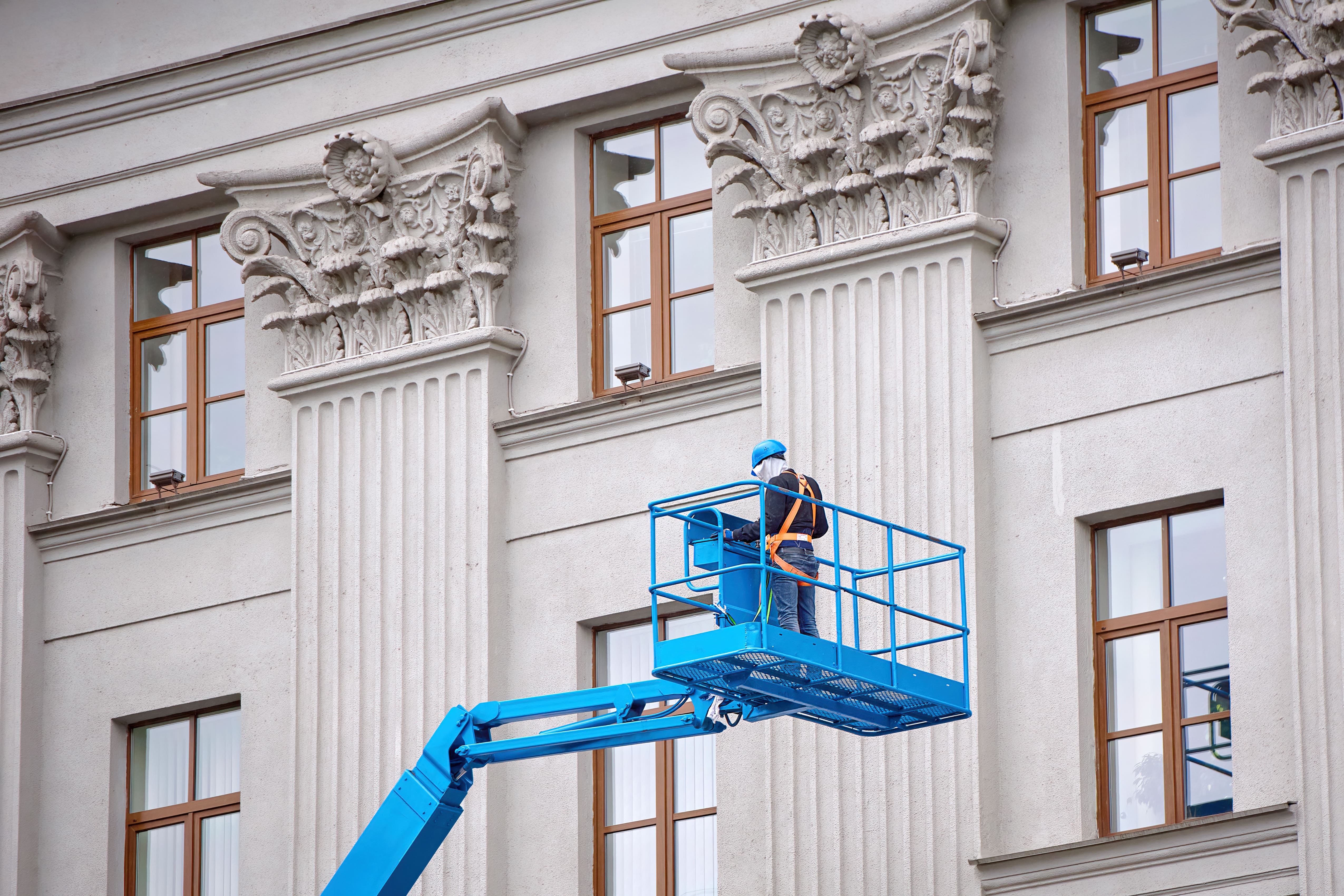 a man on a lift in front of a building