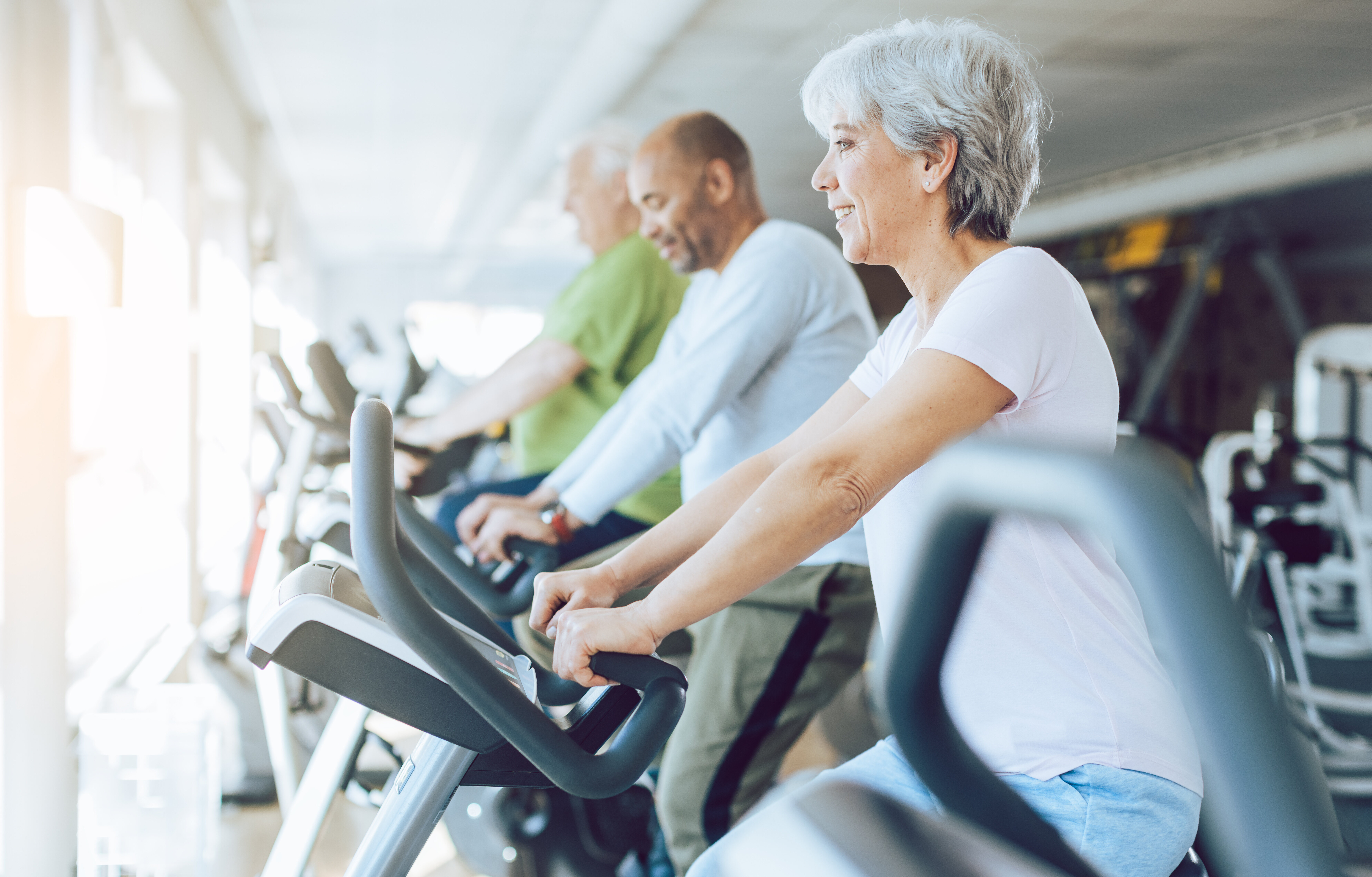 seniors exercising on stationary equipment stock image