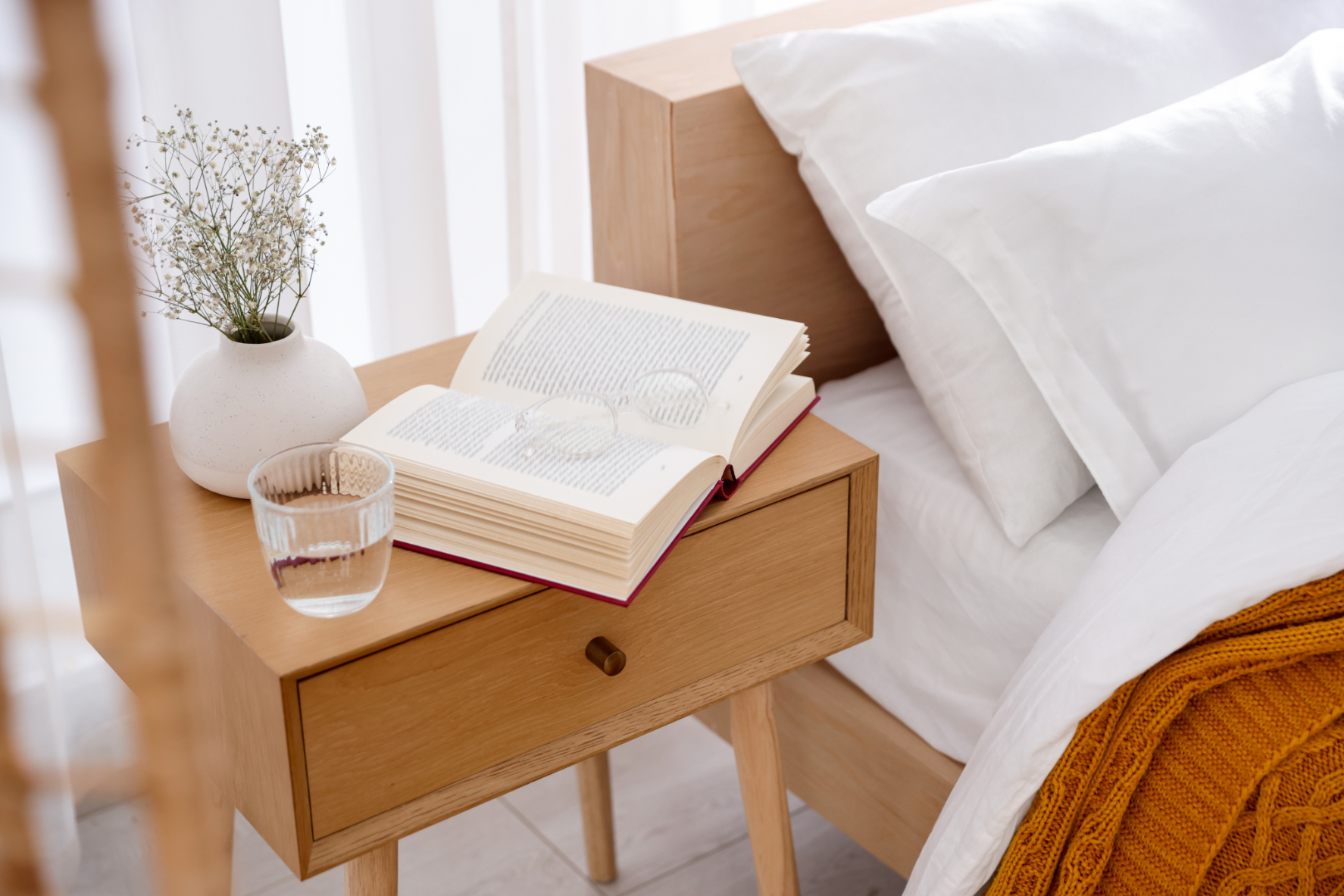 bed with bedside table and books stock image
