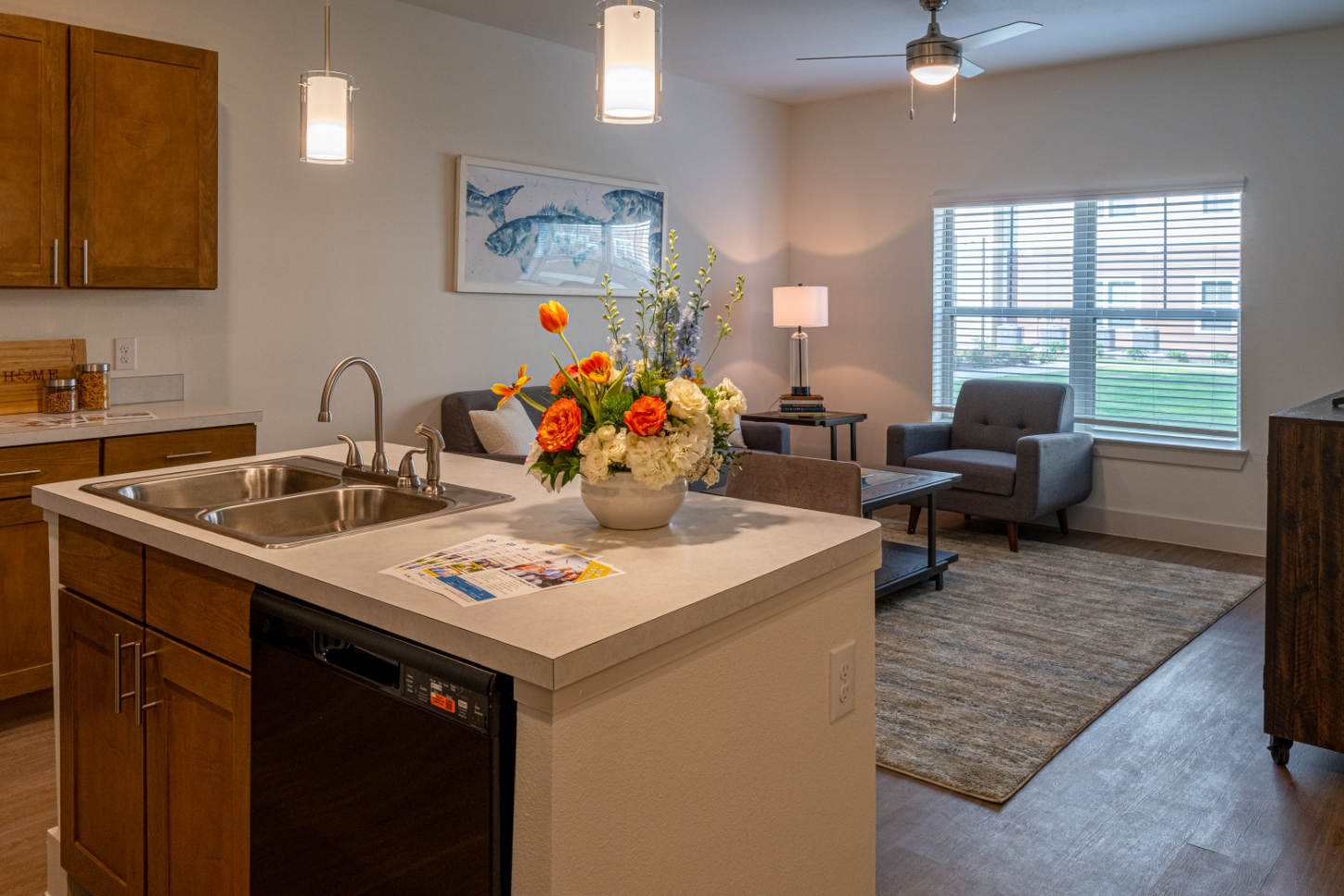 Kitchen island with brown cabinets and view into living area with sofa