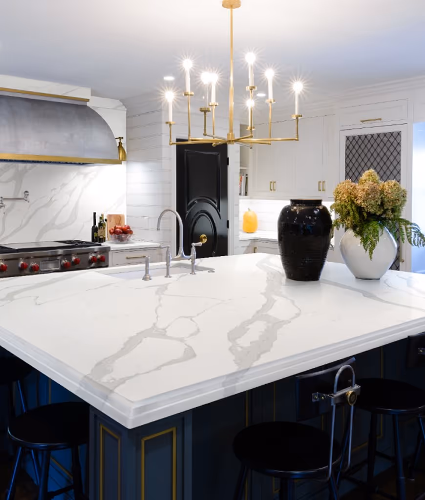 A kitchen with a marble counter top and a chandelier.