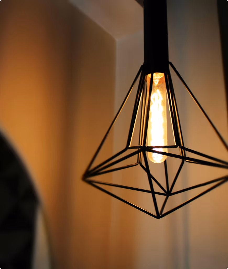 A light fixture with a triangle shape and a bulb inside.