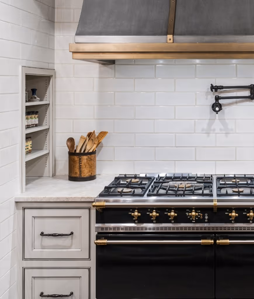 A black and gold oven with a stove top and a wooden spoon holder.