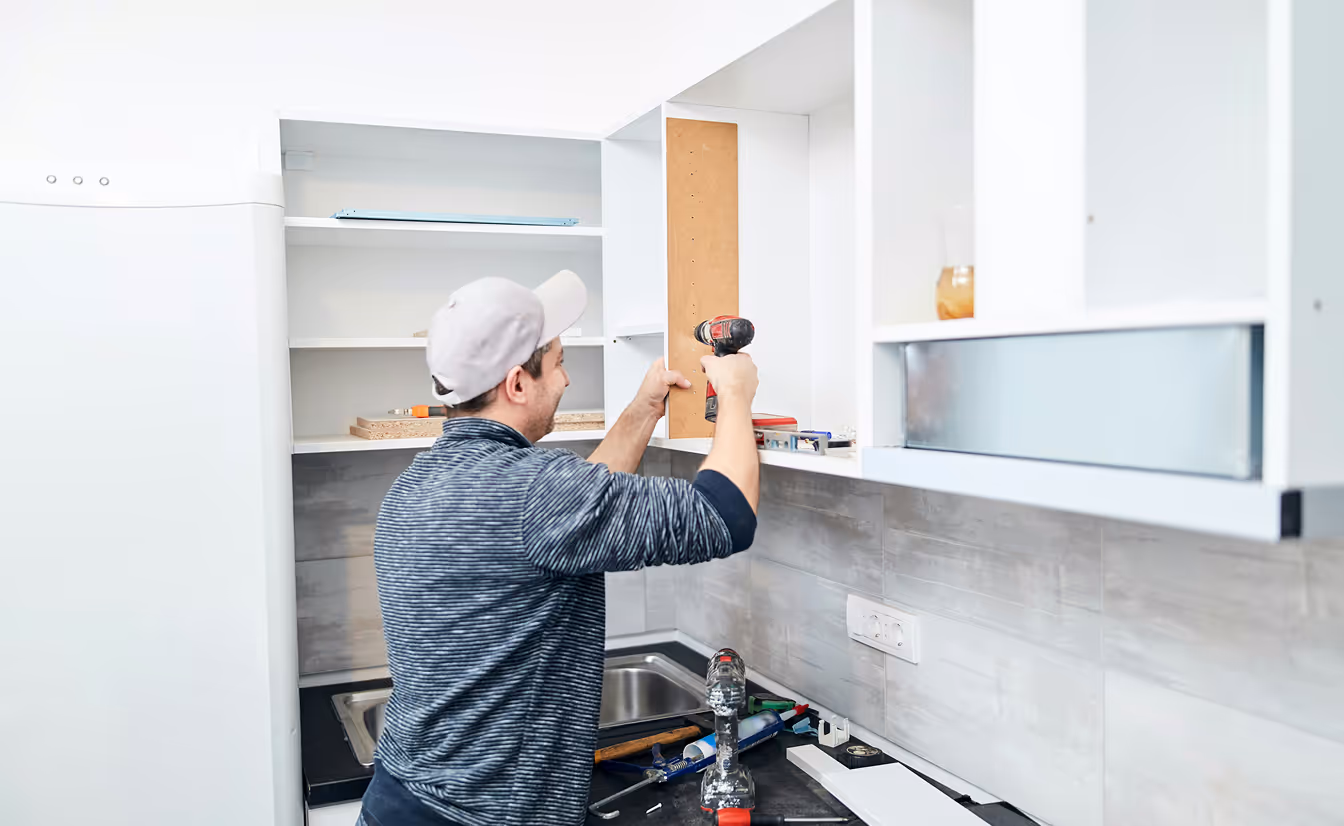 man installing cabinets