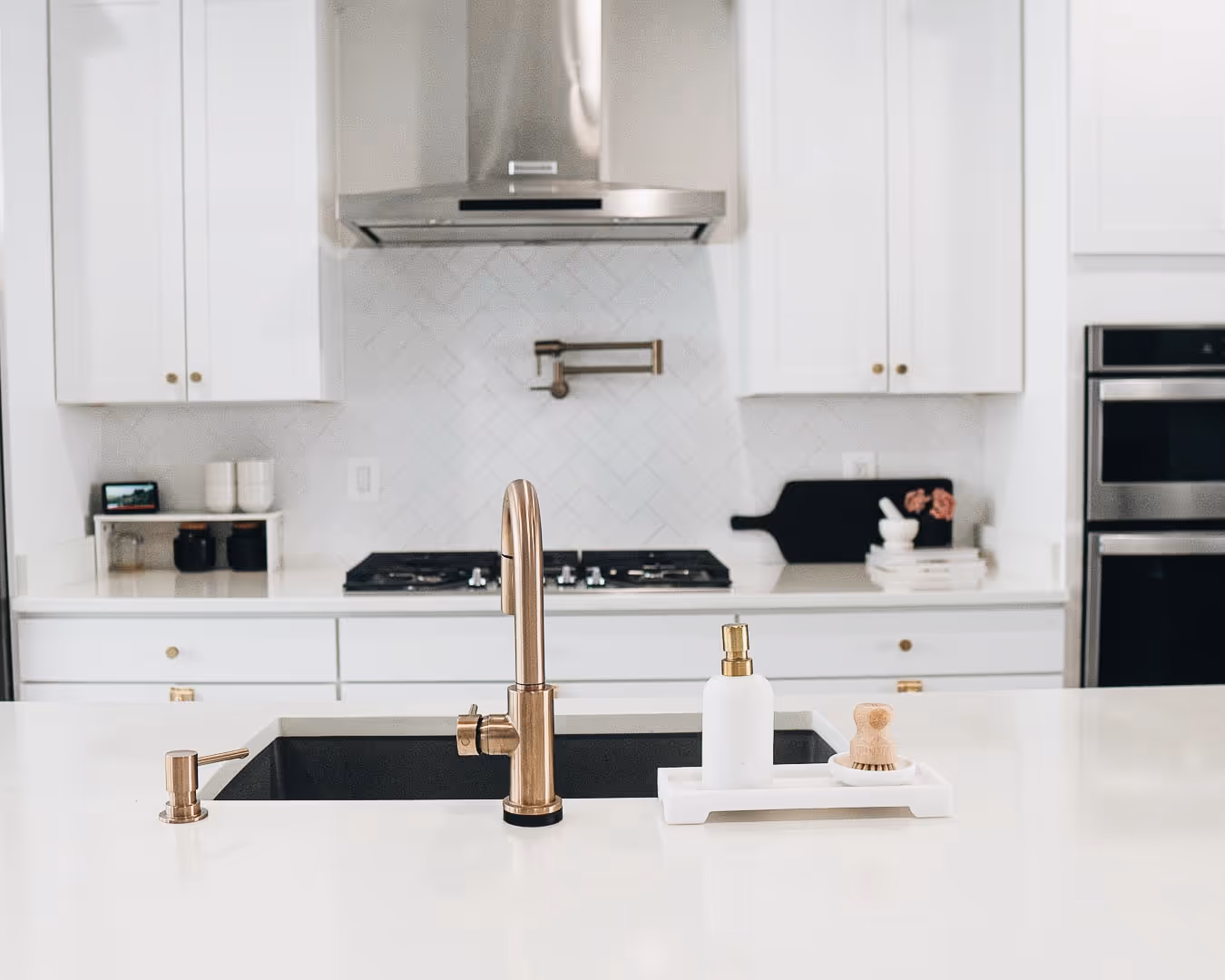 A kitchen with a sink and a stove top oven.