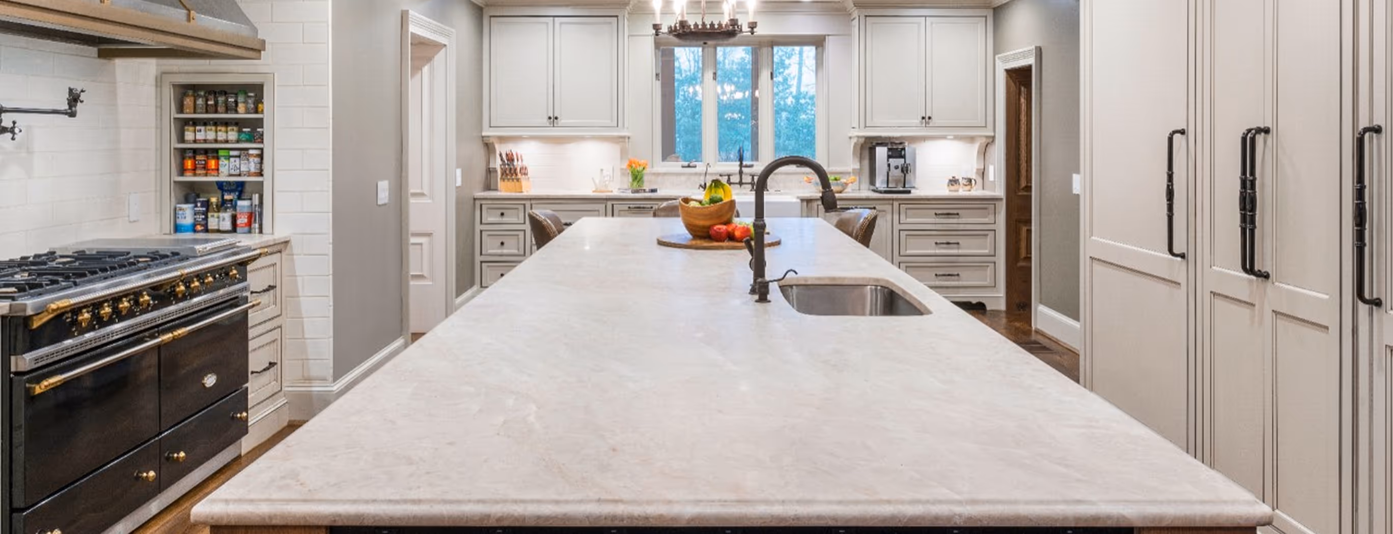 A kitchen with a marble counter top and a faucet.
