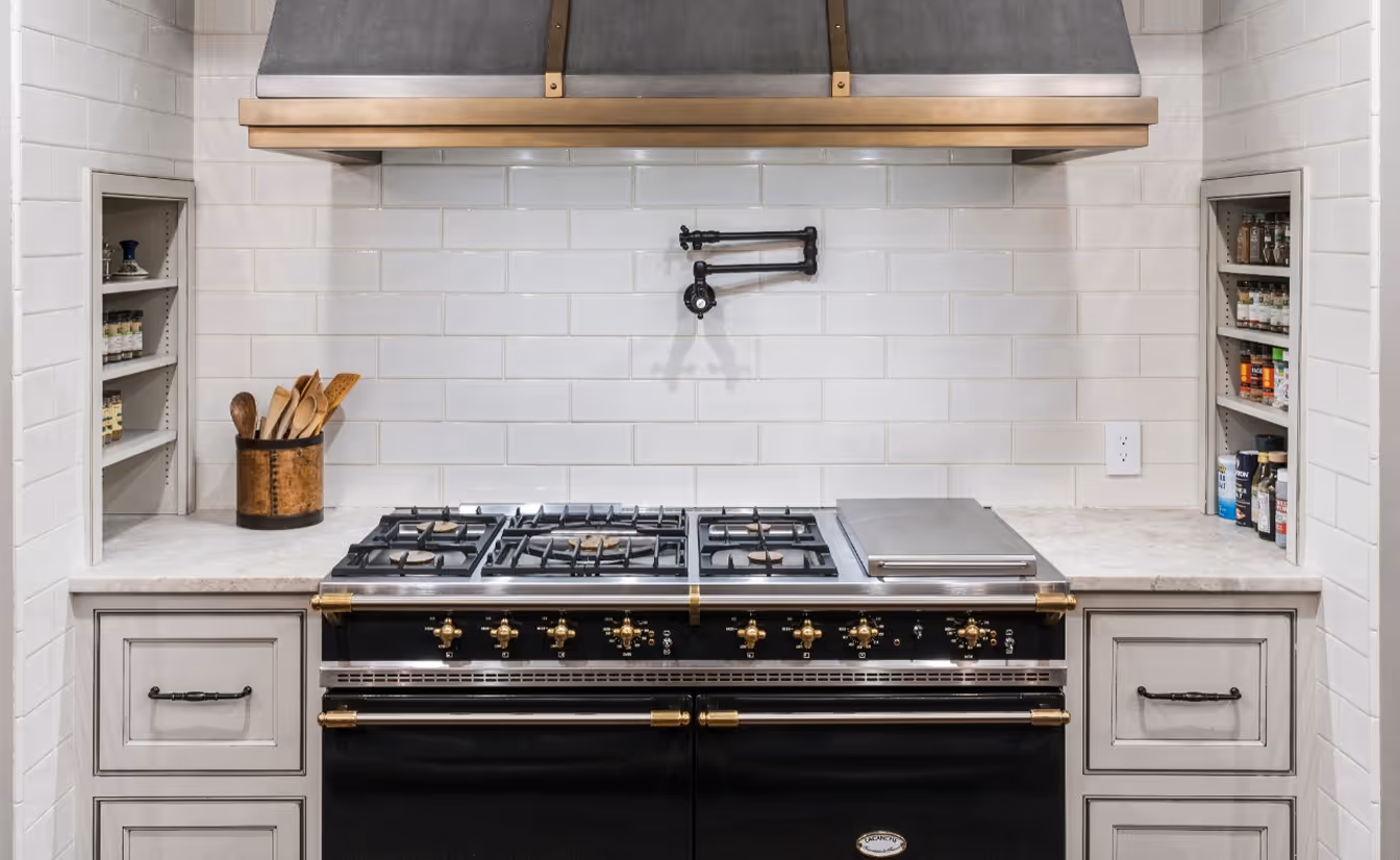 A kitchen with subway wall tiling and a pot filler.