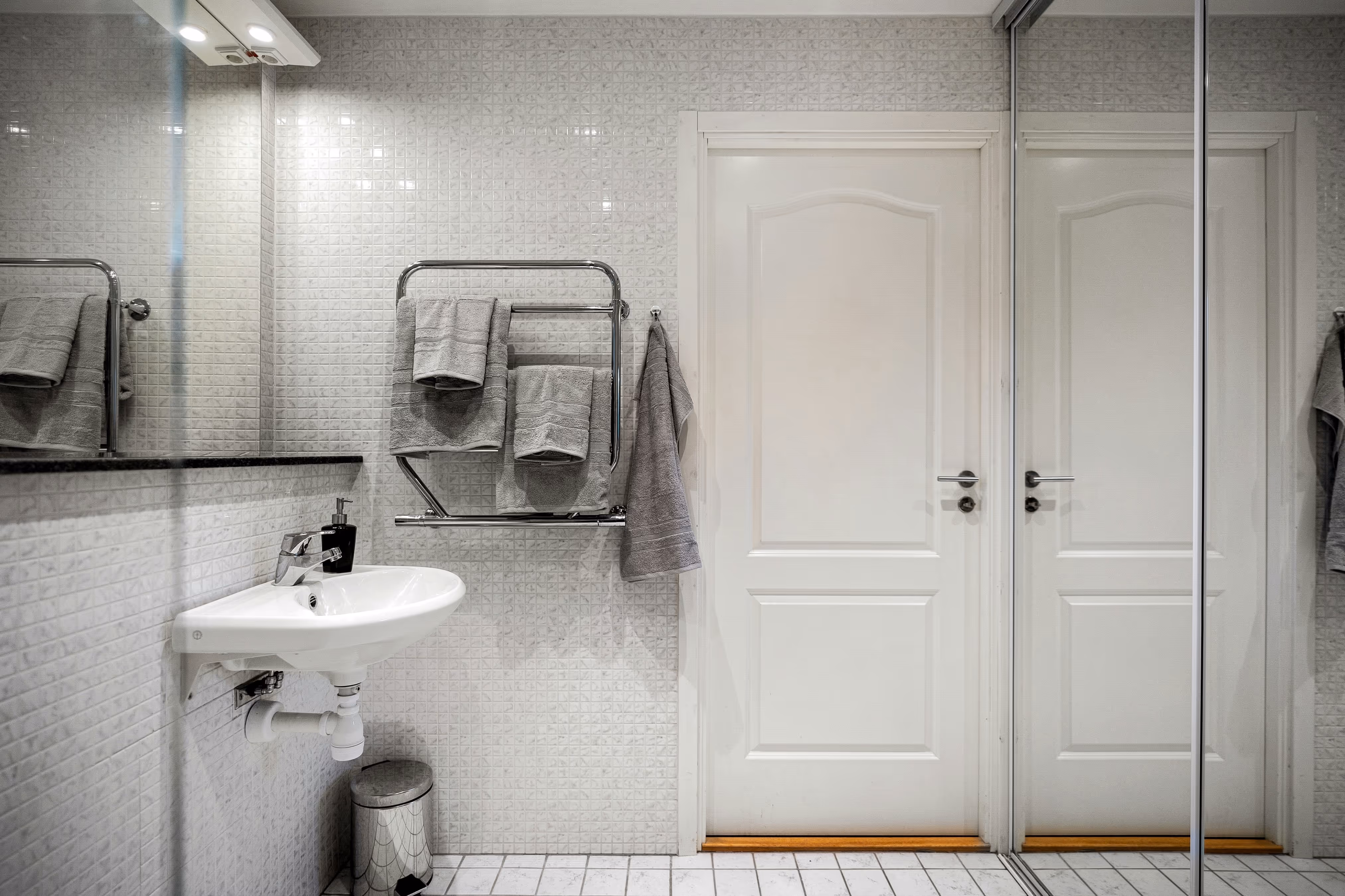 A bathroom with a white sink and a towel rack.