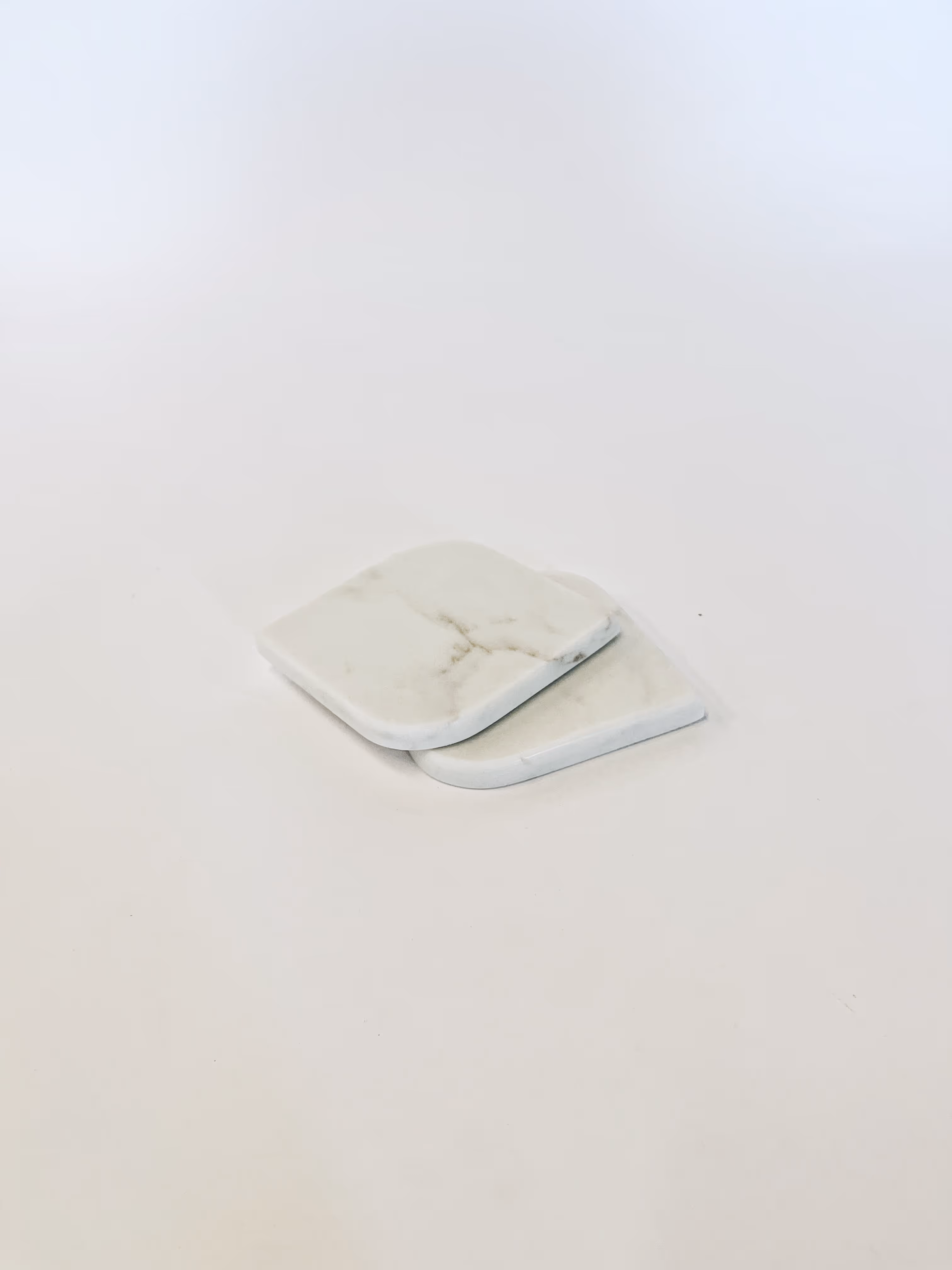 White marble coasters on a white table