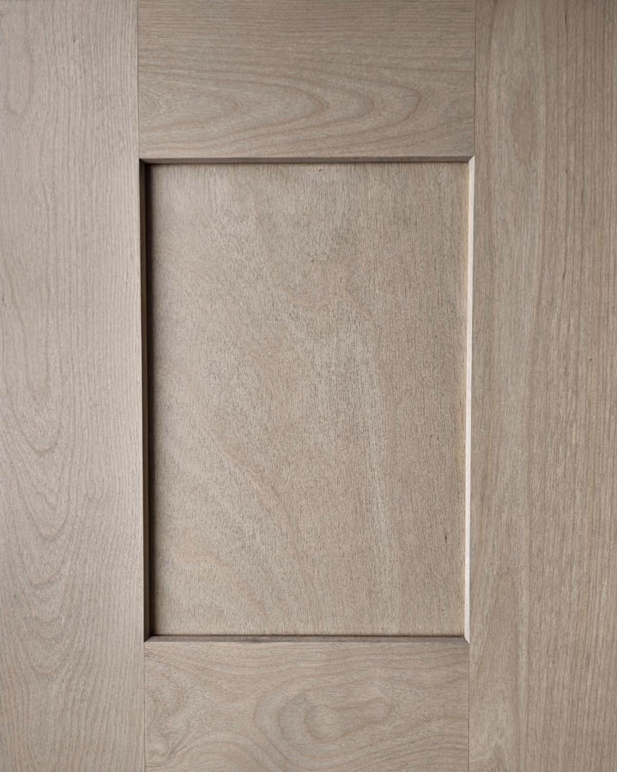 A spacious kitchen featuring a large island with a marble countertop, dark wooden cabinets, and a gas range. Natural light enters through a window, illuminating the room's modern appliances and neutral color scheme.