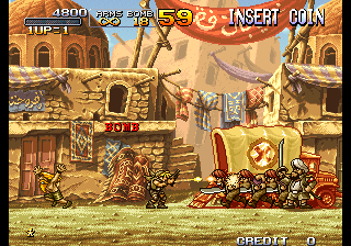 Pixel-art side-scrolling shooter game scene with soldiers battling near Middle Eastern-style buildings and a large red vehicle.
