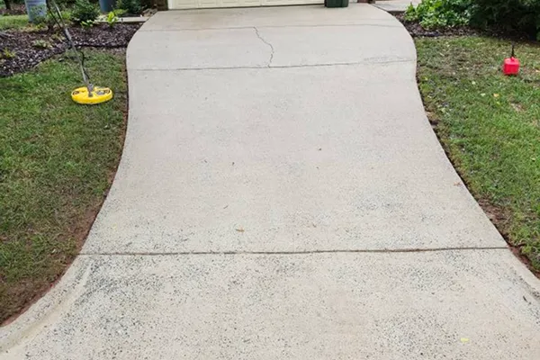 A picture of a driveway that is clean of dirt after a pressure washing