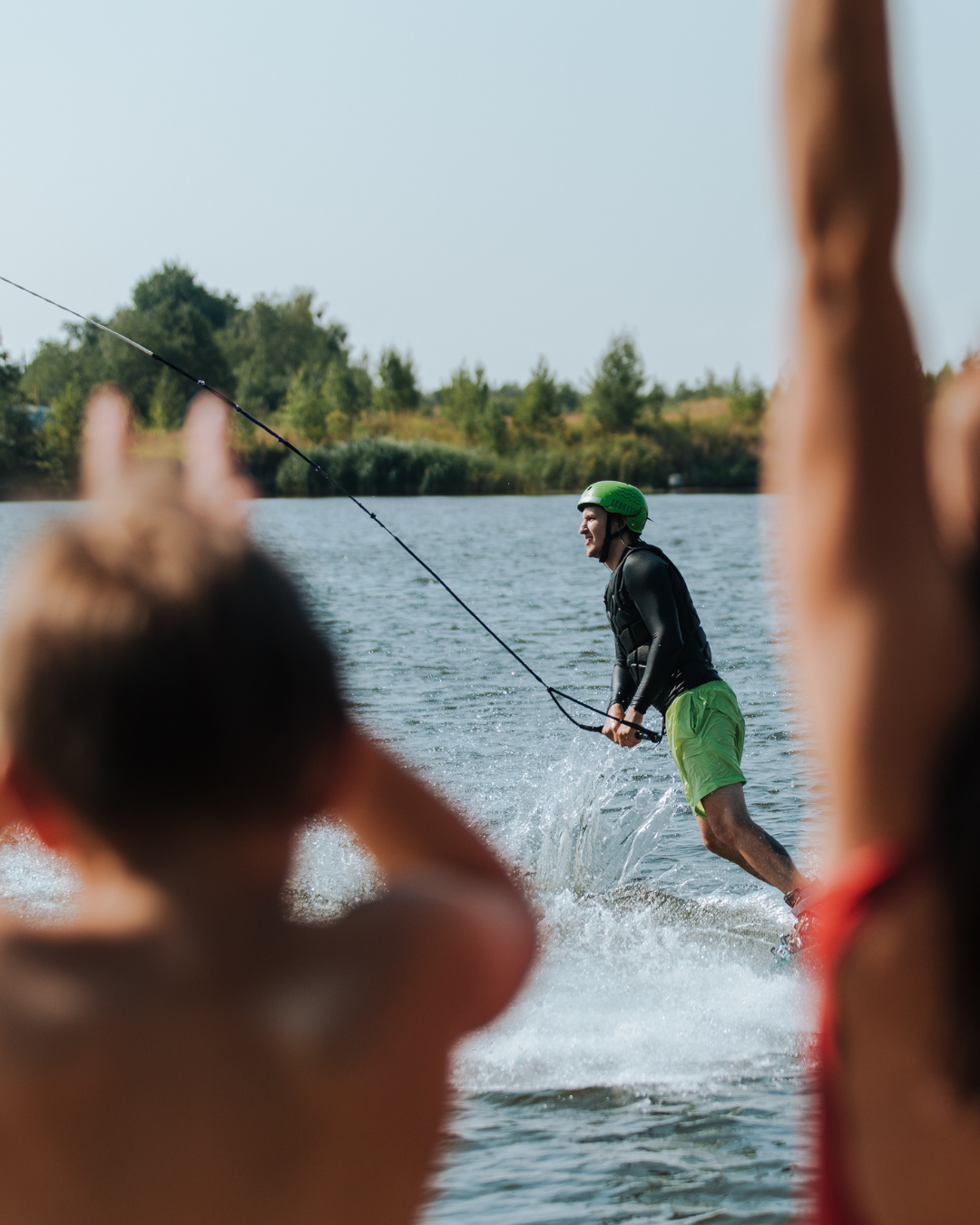 A wakeboarder riding at a cable park, testing WakeMate, supported by other test riders.