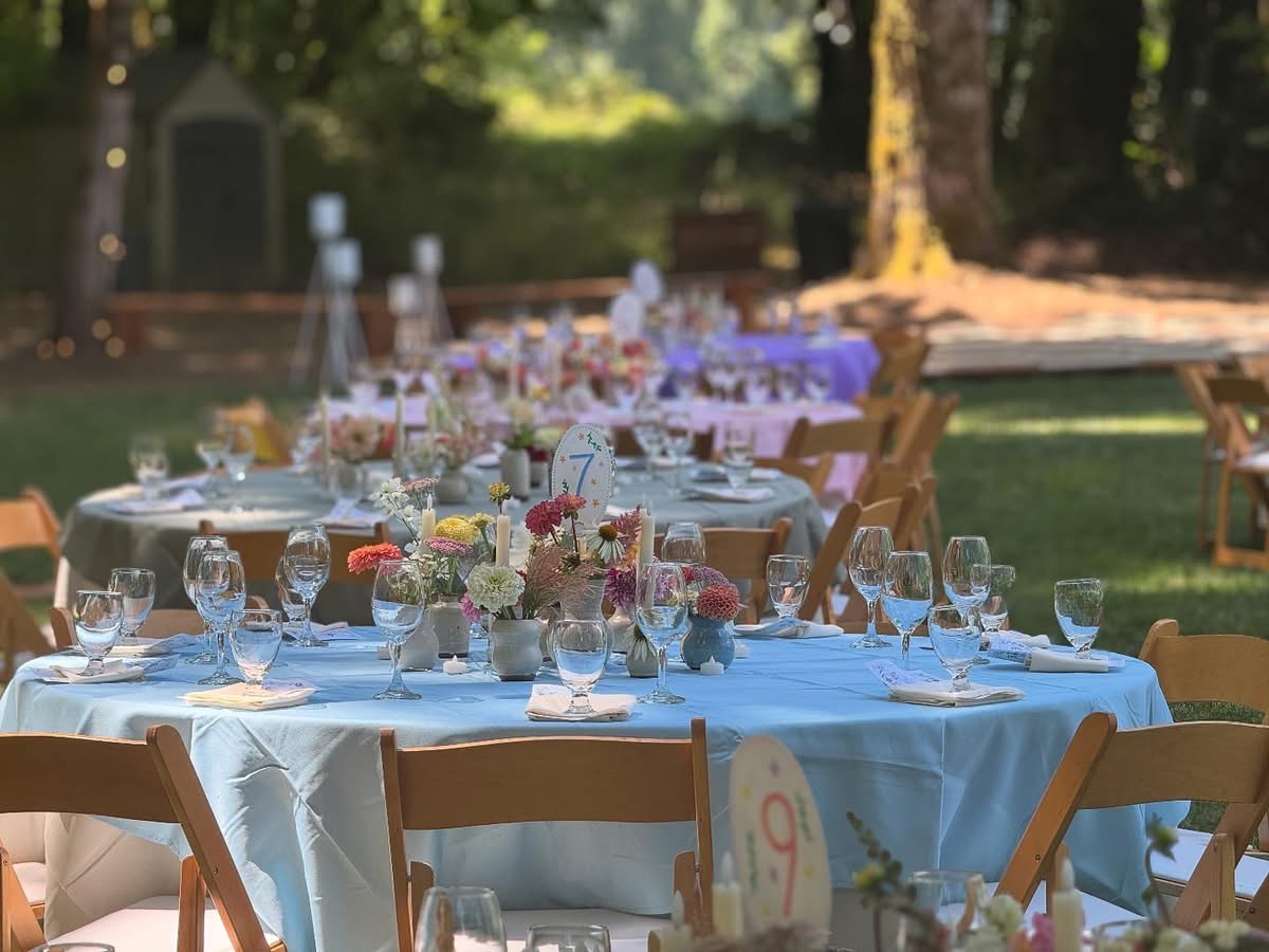 Group of people dancing on a checkered dance floor at an outdoor nighttime event with string lights overhead.