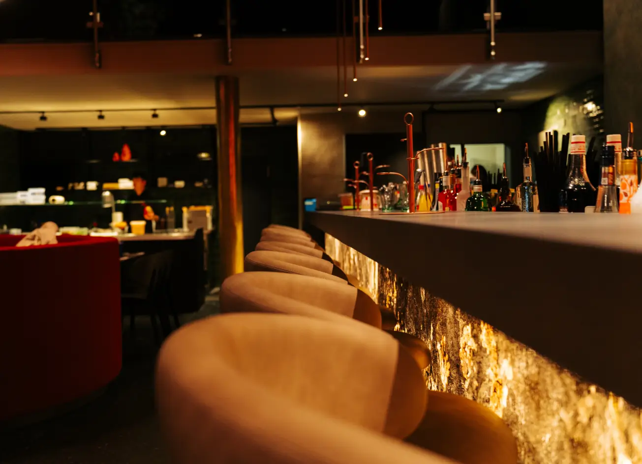 Barhocker an der stimmungsvoll beleuchteten Bar im MOGGI