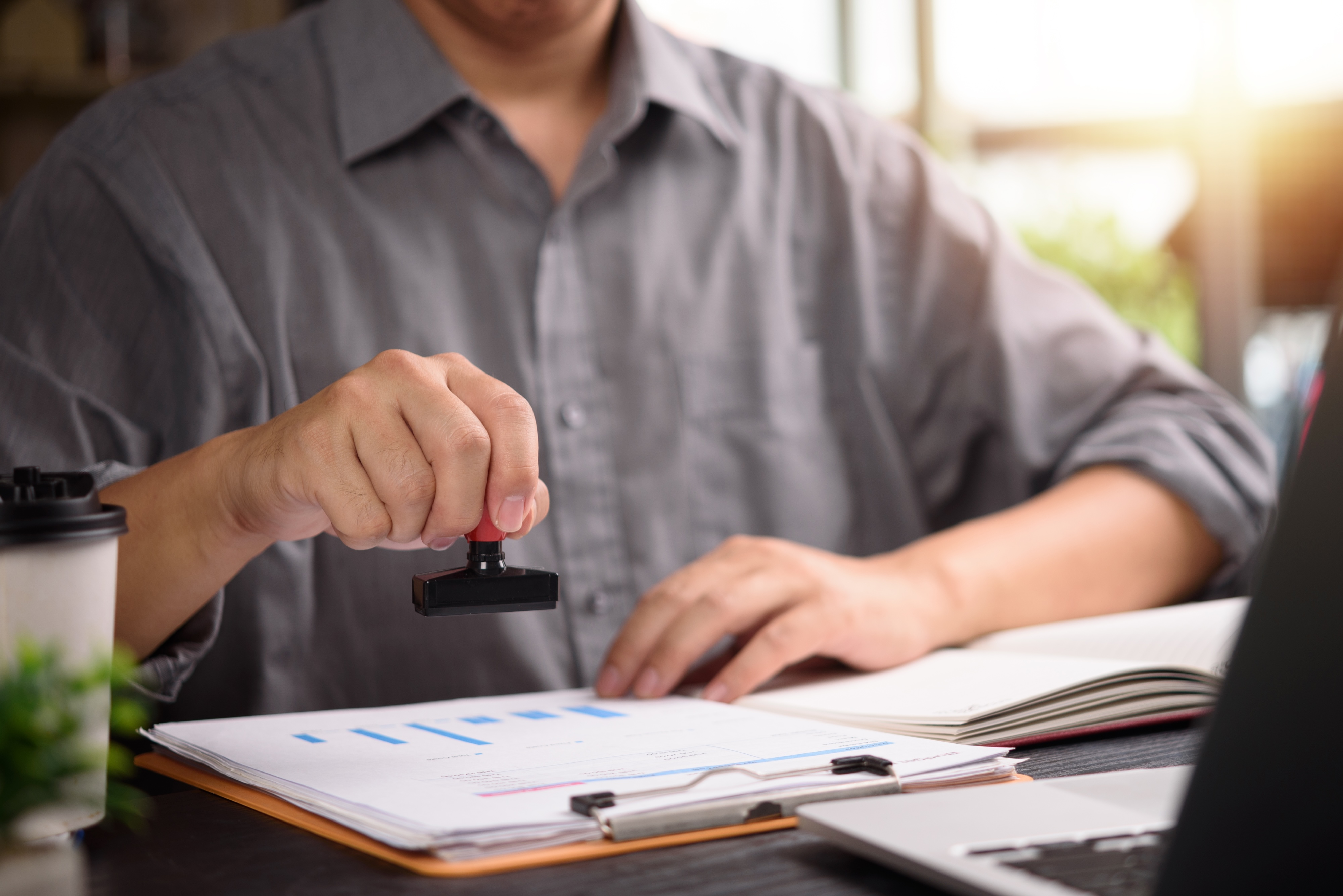 person in büro stempelt einen zettel