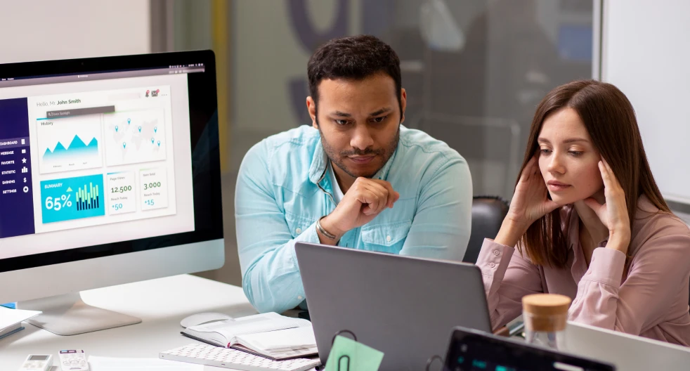 a man and a woman looking at a computer screen