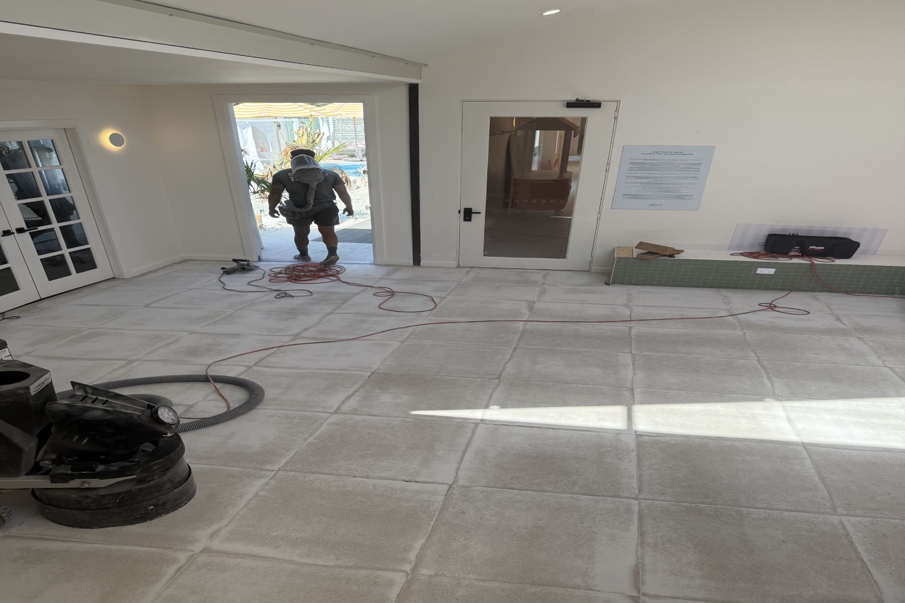 Mechanically abraded floor tiles at the Douglas Park bath house before epoxy coating