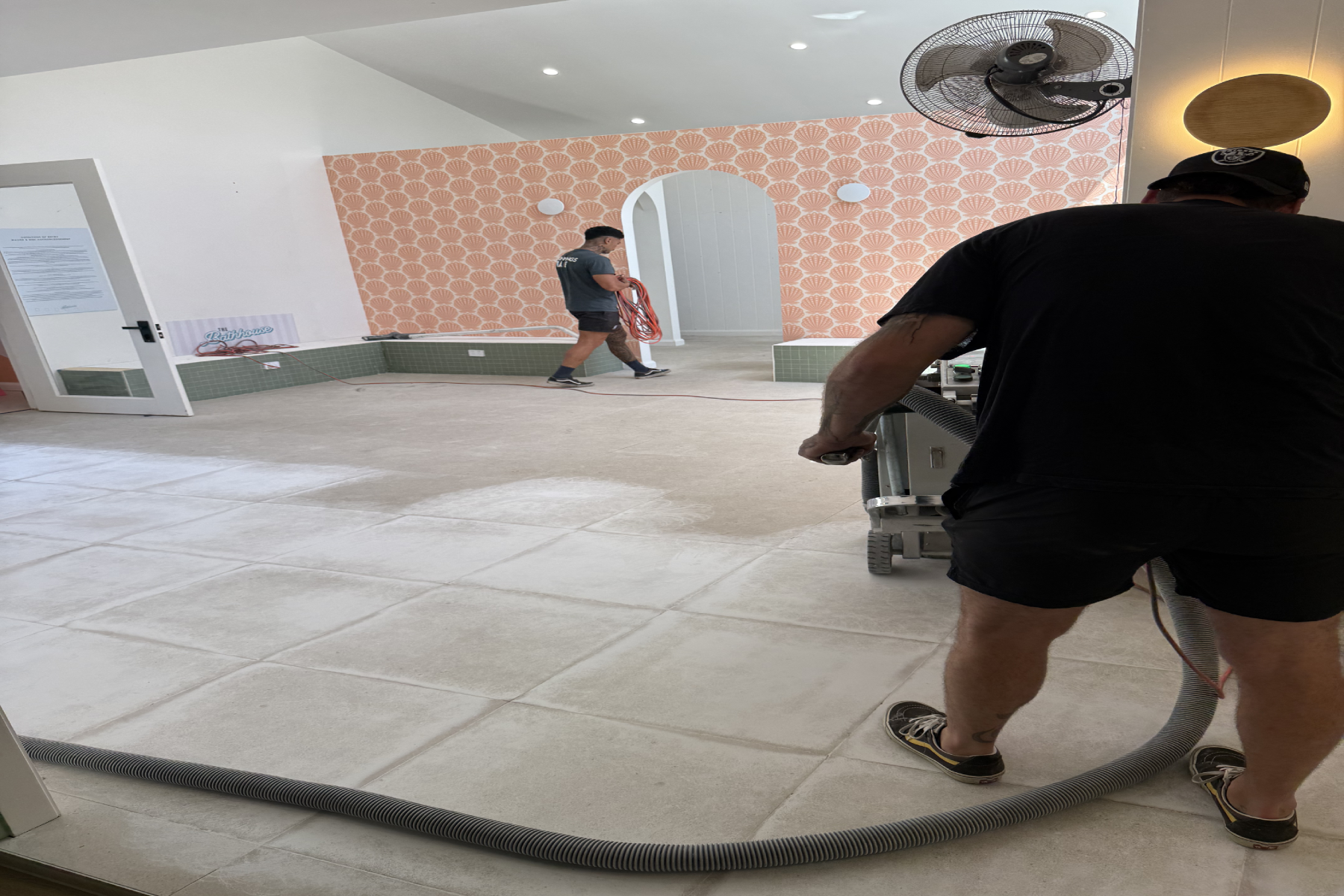Mechanical tile grinding with dust extraction at the Douglas Park bath house before epoxy flooring